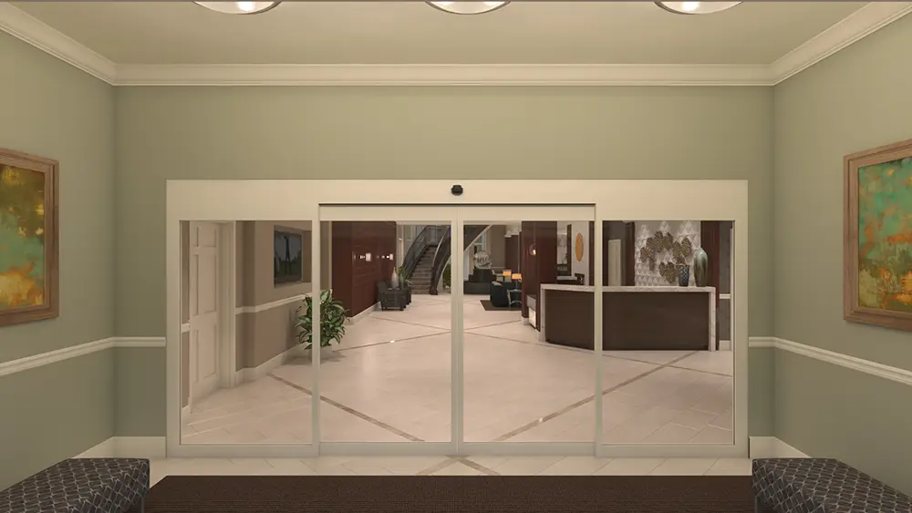 L1_0048 A lobby entrance with automatic sliding glass doors, beige walls, artwork, seating on both sides, and a view of the reception desk and stairs inside.