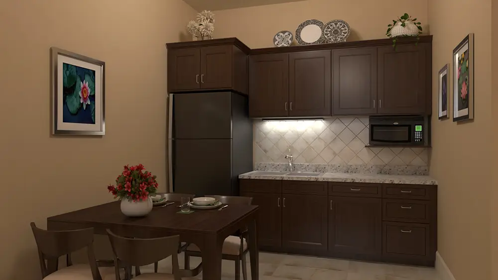 RU-c2_0000 A small kitchen with dark wood cabinets, a refrigerator, a microwave, and a dining table set for four with a red flower centerpiece.